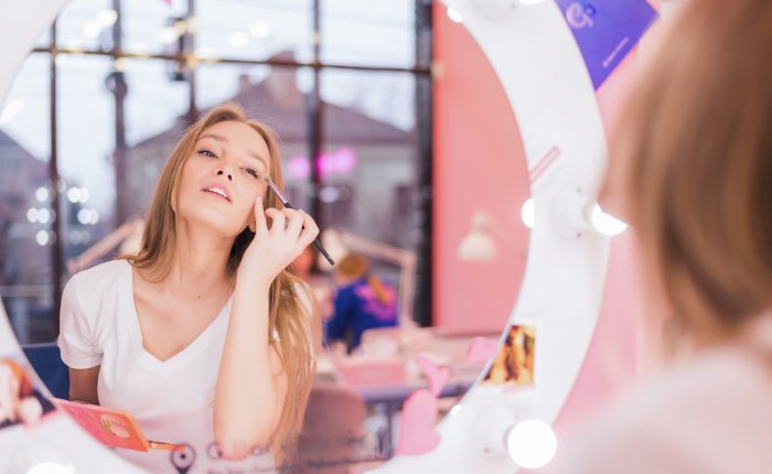 Young girl does make-up in a beauty salon The girl in front of the mirror is making up Beauty saloon